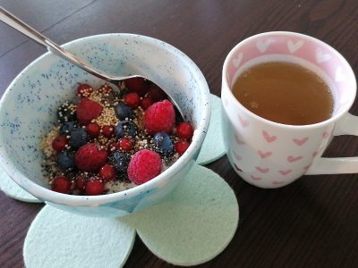 warmes Frühstück Arbeitsalltag, frische Beeren und Teehäferl